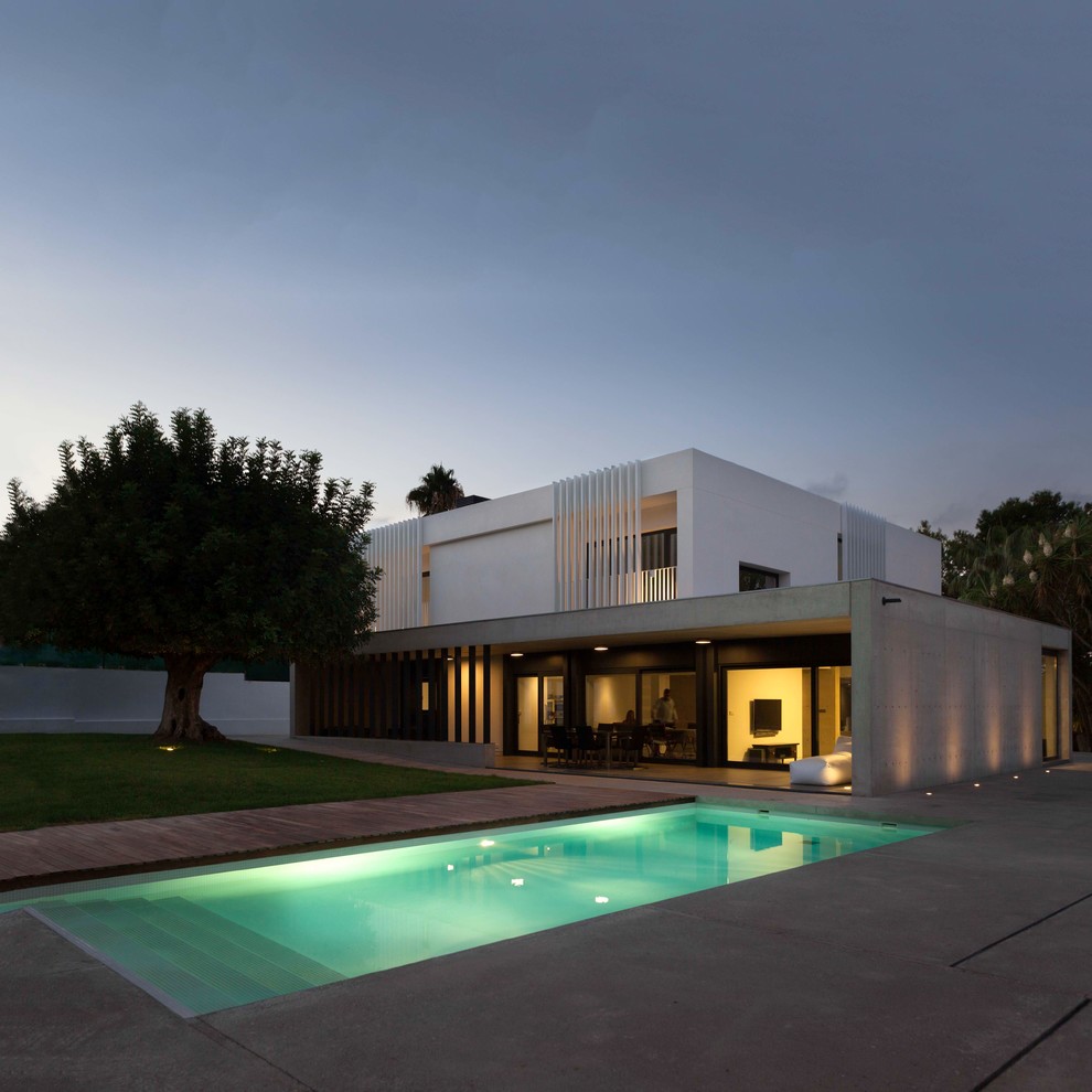 Идея дизайна: двухэтажный, белый частный загородный дом в стиле модернизм с облицовкой из бетона и плоской крышей