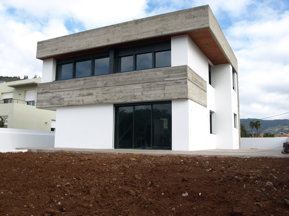 Medium sized and white contemporary two floor house exterior in Other with mixed cladding and a flat roof.