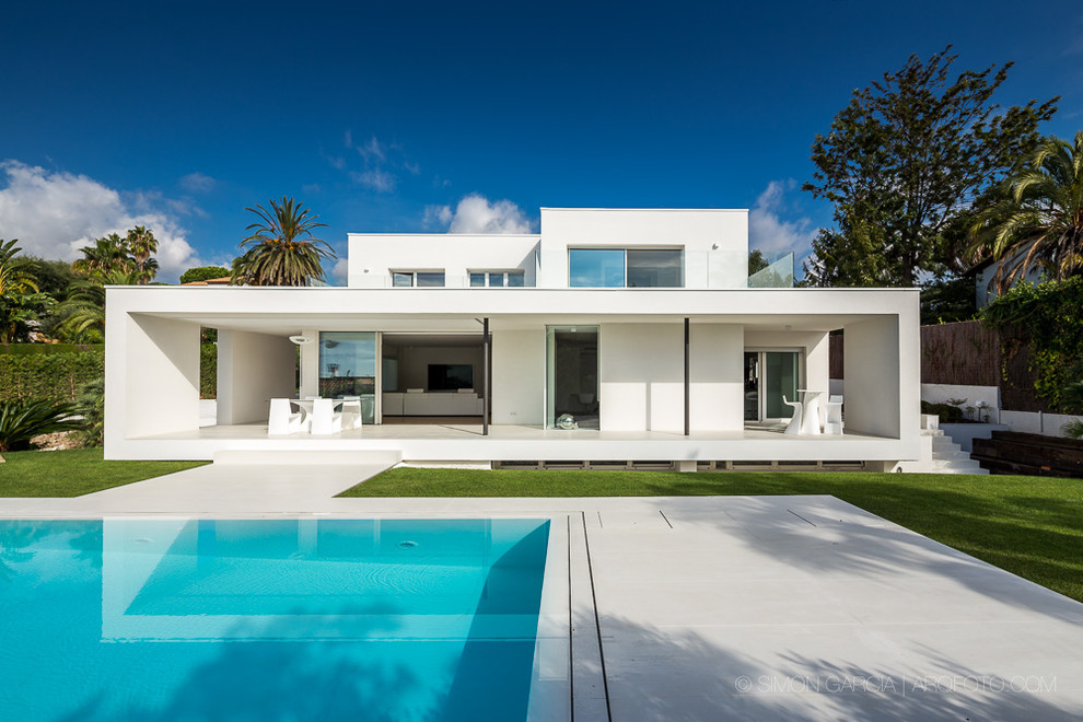 Réalisation d'une façade de maison blanche design en stuc à un étage et de taille moyenne avec un toit plat.