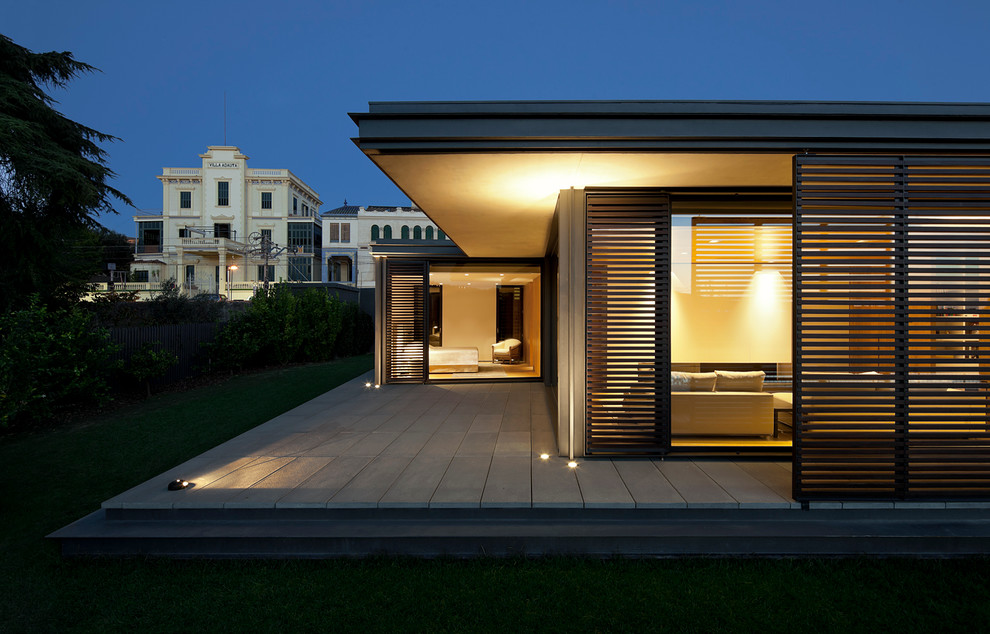 Idee per la facciata di una casa contemporanea a un piano di medie dimensioni con rivestimento in vetro e tetto piano