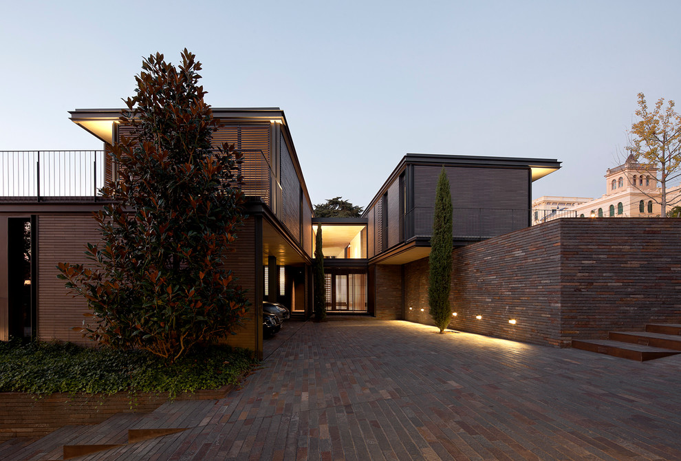 Idée de décoration pour une grande façade de maison marron design en brique à un étage avec un toit plat.