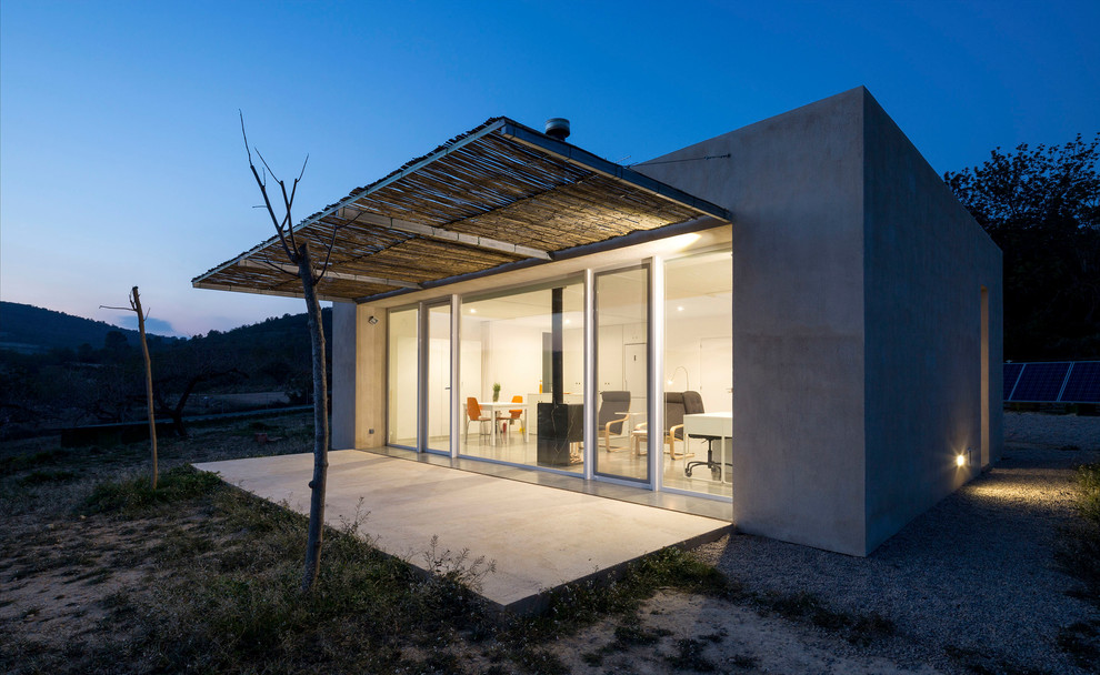 Inspiration för ett litet funkis grått hus, med allt i ett plan, platt tak och fiberplattor i betong