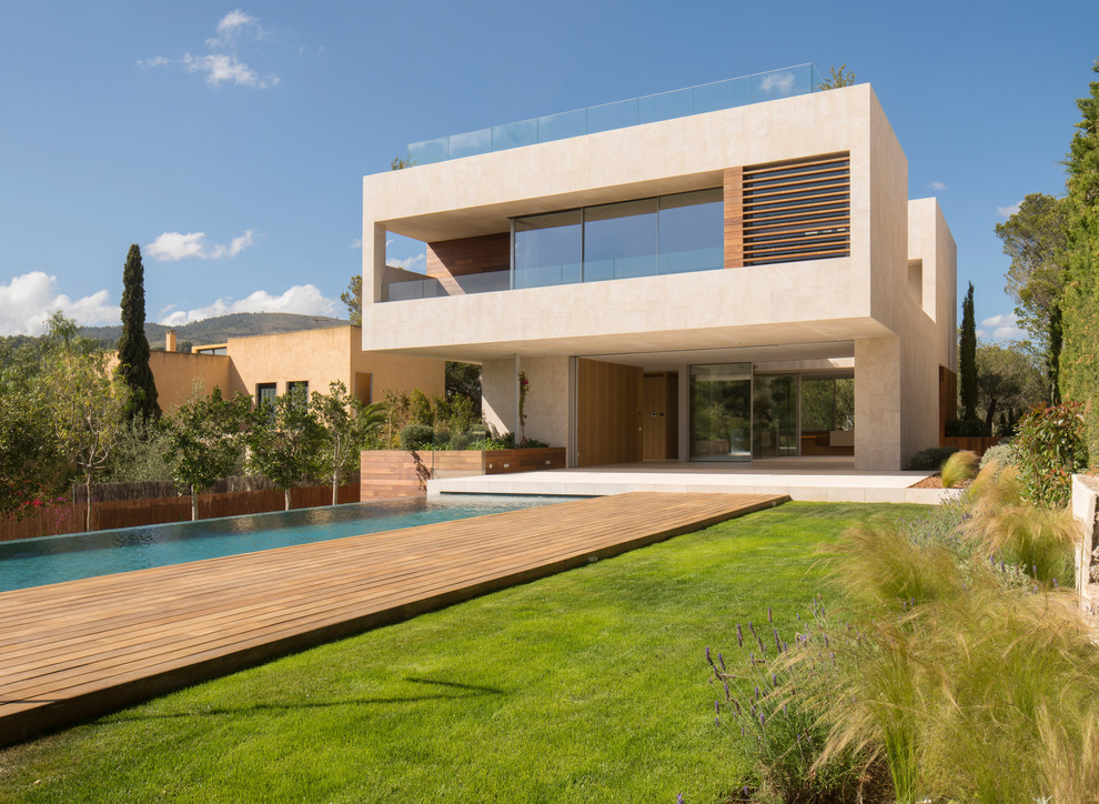Modelo de fachada de casa beige minimalista grande de dos plantas con revestimiento de piedra y tejado plano