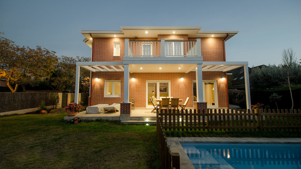 Diseño de fachada de casa roja clásica de tamaño medio de dos plantas con revestimiento de ladrillo y tejado a cuatro aguas