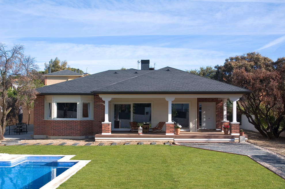 Photo of a medium sized traditional bungalow house exterior in Madrid with mixed cladding and a hip roof.