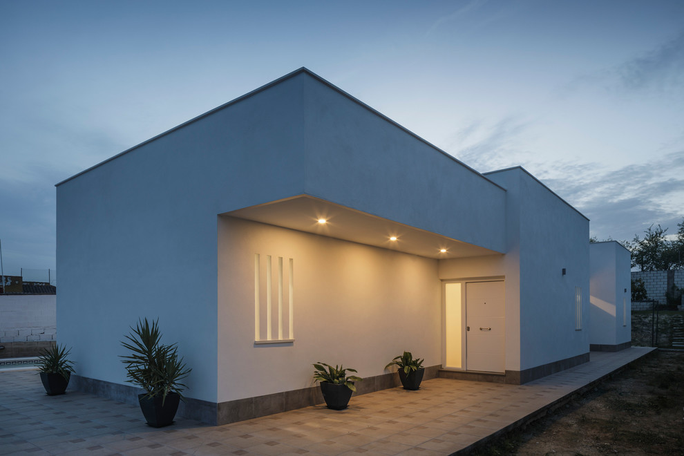 Diseño de fachada blanca minimalista grande de una planta con revestimientos combinados y tejado plano