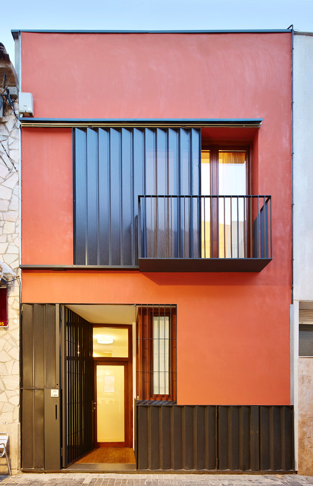 Mittelgroßes, Zweistöckiges Modernes Einfamilienhaus mit Putzfassade, roter Fassadenfarbe und Flachdach in Barcelona