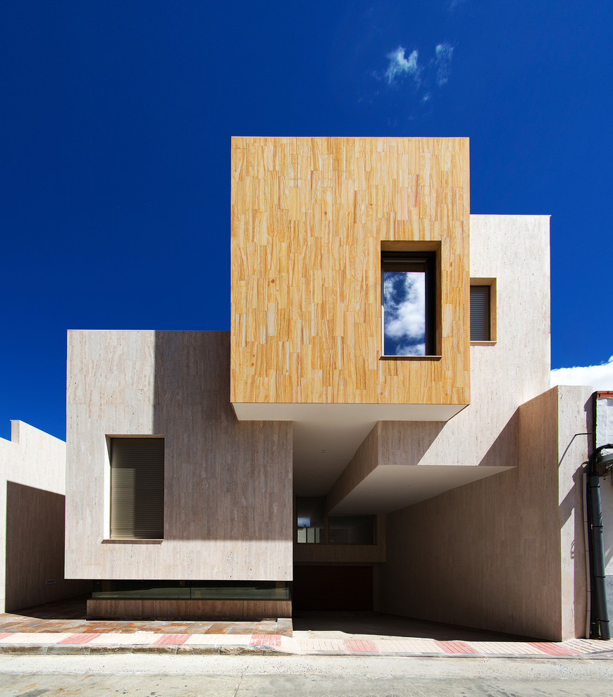 Immagine della villa grande beige contemporanea a tre piani con rivestimenti misti e tetto piano