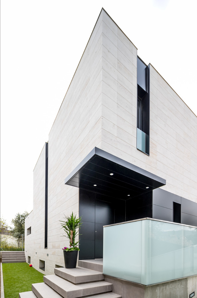 Modelo de fachada de casa minimalista de tamaño medio de dos plantas con revestimiento de piedra y tejado plano
