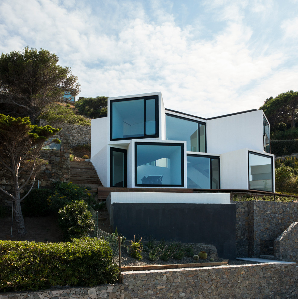 Идея дизайна: двухэтажный, белый дом среднего размера в современном стиле с облицовкой из цементной штукатурки и плоской крышей
