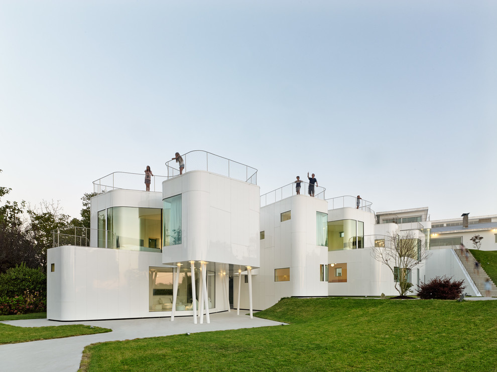 Immagine della villa grande bianca contemporanea a due piani con rivestimento in metallo e tetto piano