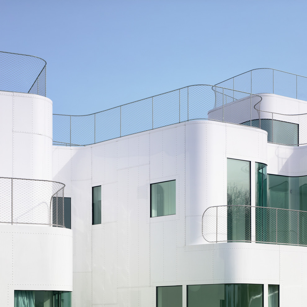 Foto della villa bianca contemporanea con rivestimento in metallo e copertura verde