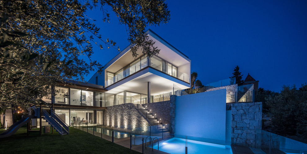 Dreistöckiges Modernes Einfamilienhaus mit Mix-Fassade, weißer Fassadenfarbe und Flachdach in Sonstige