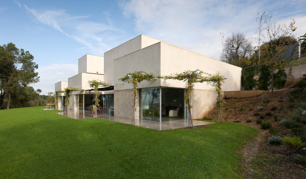 Immagine della facciata di una casa grande beige contemporanea a due piani con rivestimento in cemento e tetto piano