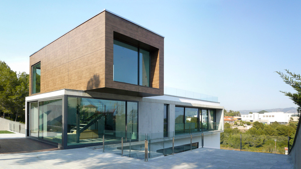 Ejemplo de fachada gris actual de tamaño medio a niveles con revestimiento de hormigón y tejado plano