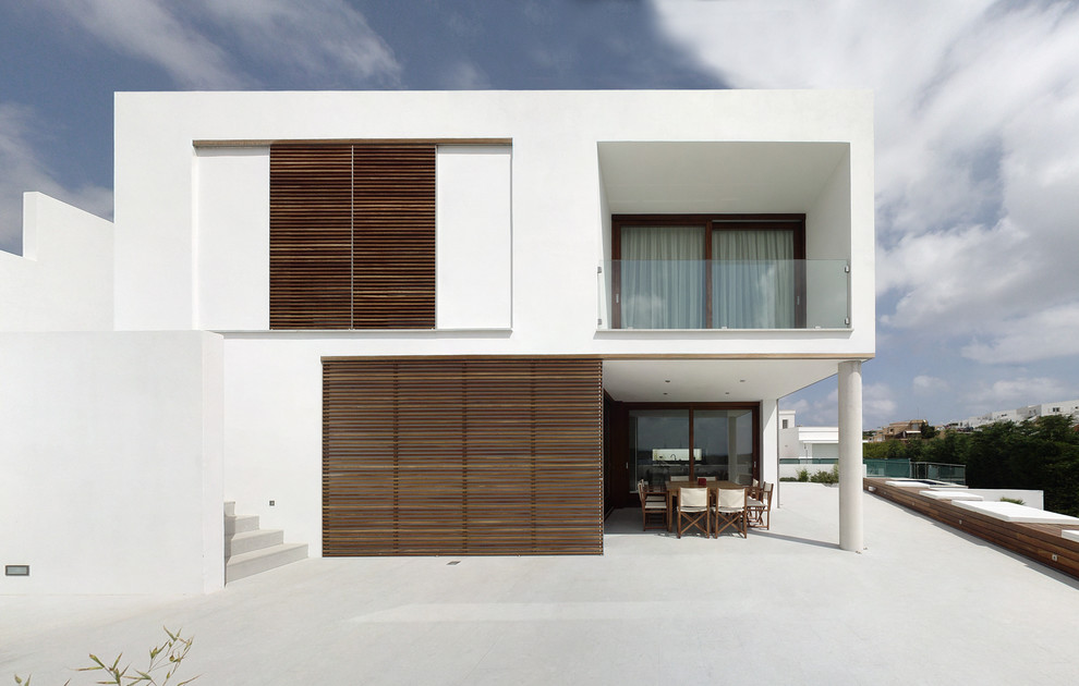 Photo of a medium sized and white mediterranean two floor render house exterior in Other with a flat roof.