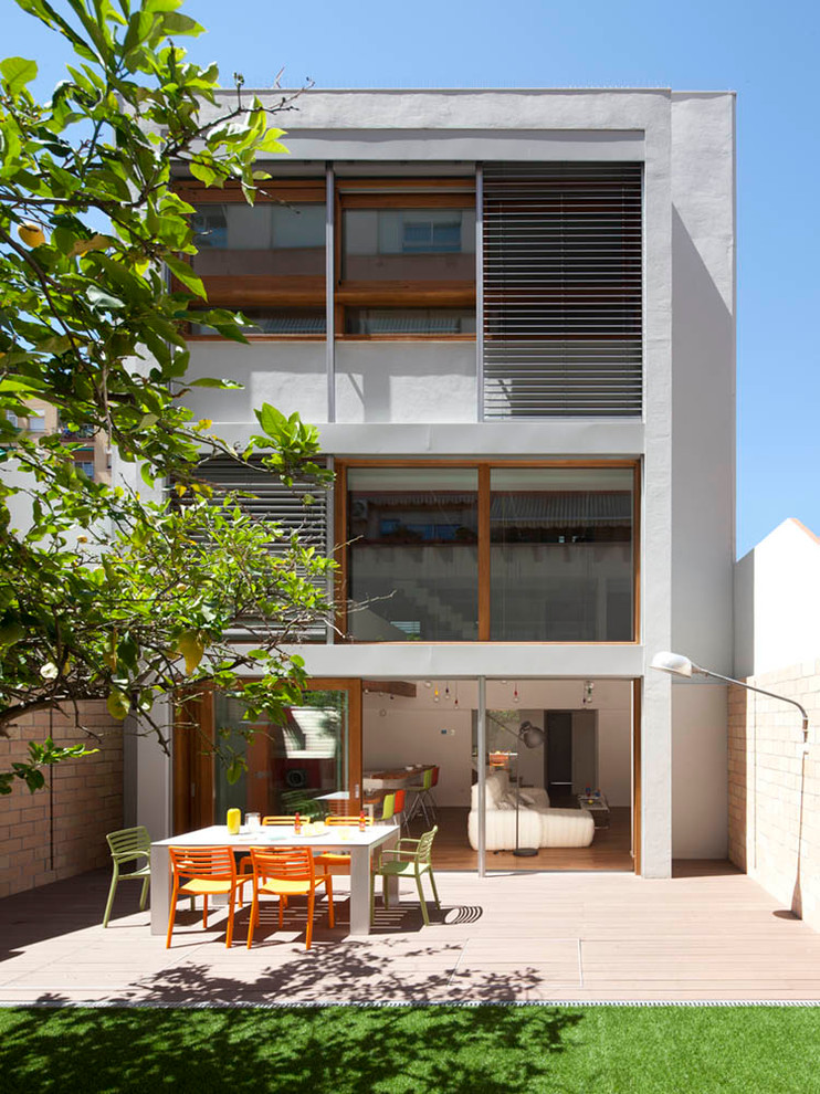 Diseño de fachada gris actual de tamaño medio de tres plantas con tejado plano y revestimiento de estuco