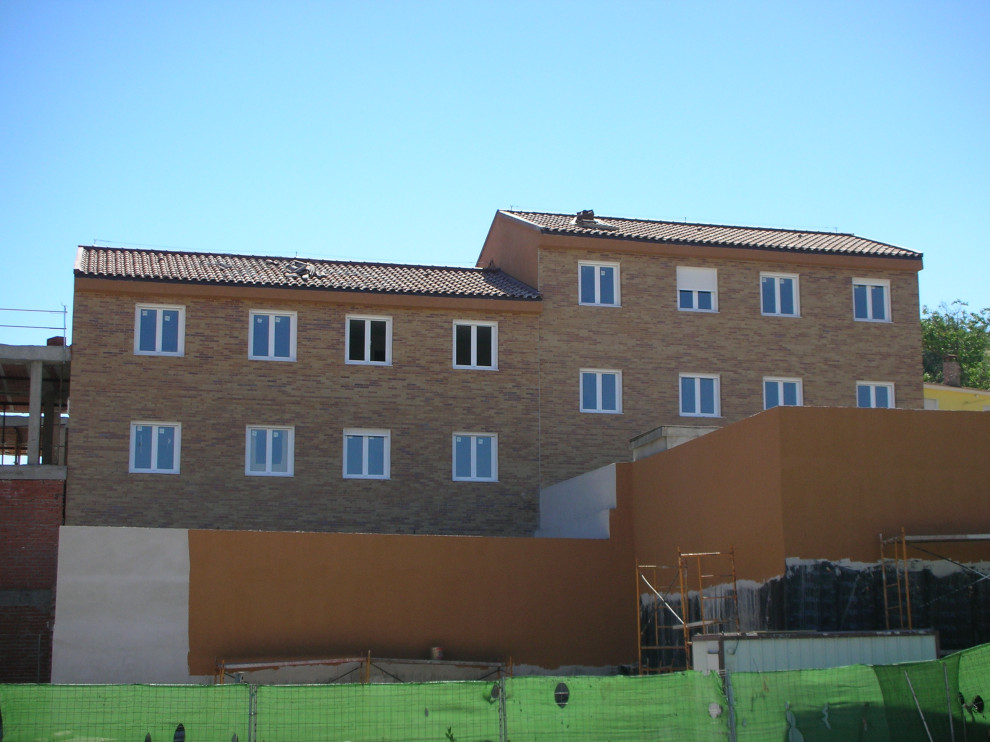 Idee per la facciata di un appartamento ampio marrone moderno a quattro piani con rivestimento in mattoni, tetto a capanna e copertura in tegole