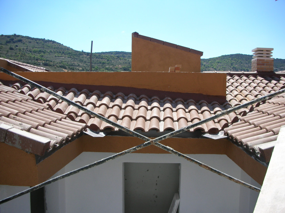Idée de décoration pour un très grande façade d'immeuble minimaliste en brique avec un toit à deux pans et un toit en tuile.