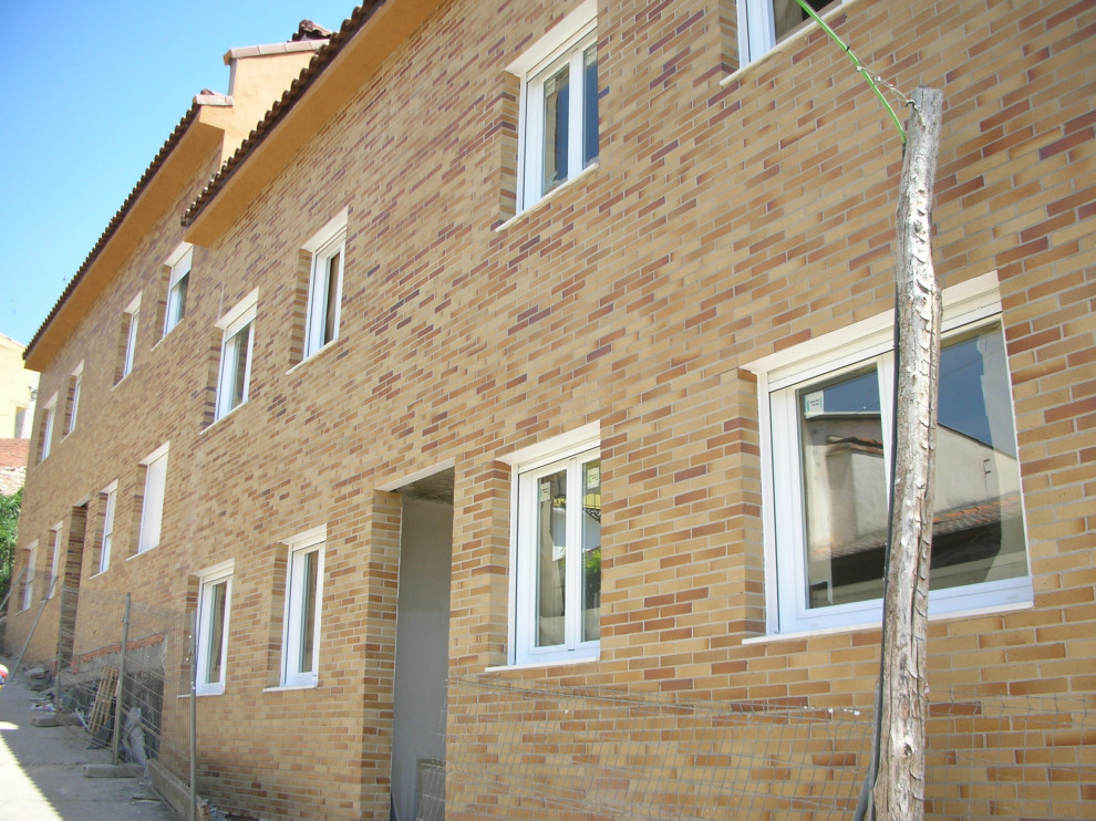 Esempio della facciata di un appartamento ampio marrone moderno a quattro piani con rivestimento in mattoni, tetto a capanna e copertura in tegole
