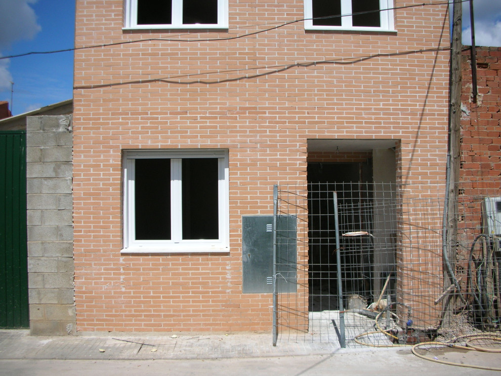 Photo of a small and red modern brick flat in Other with three floors, a pitched roof and a tiled roof.