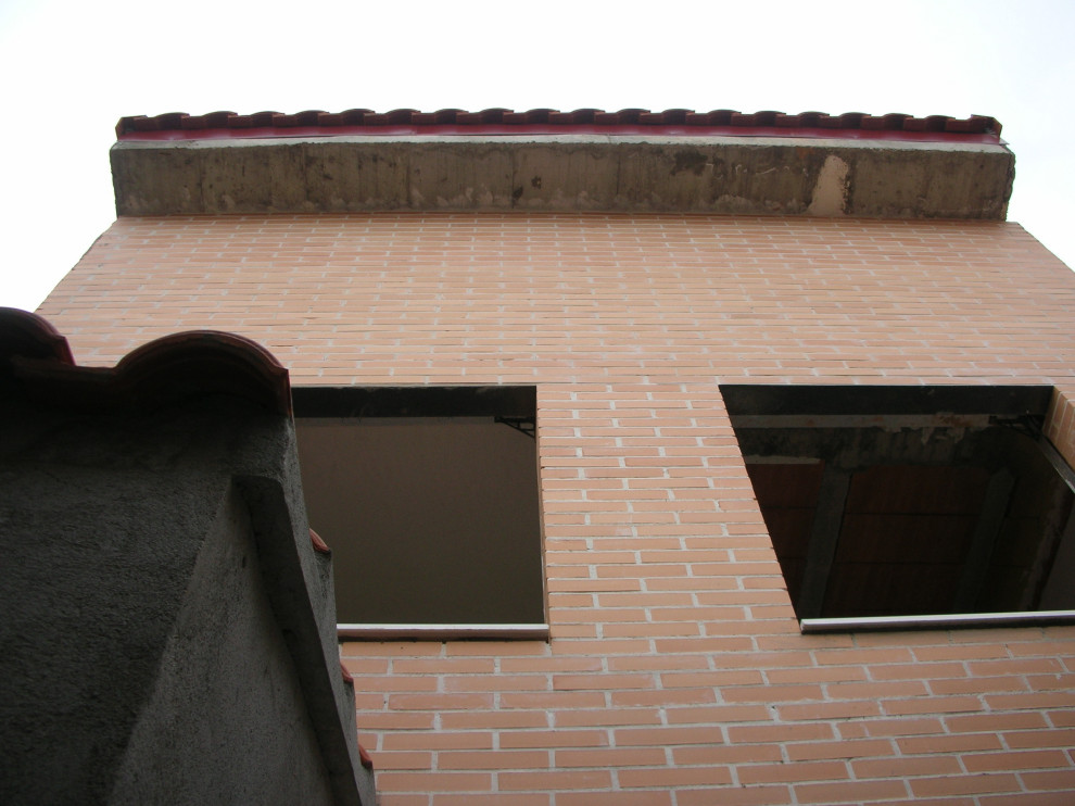 Bild på ett litet funkis rött lägenhet, med tre eller fler plan, tegel, sadeltak och tak med takplattor