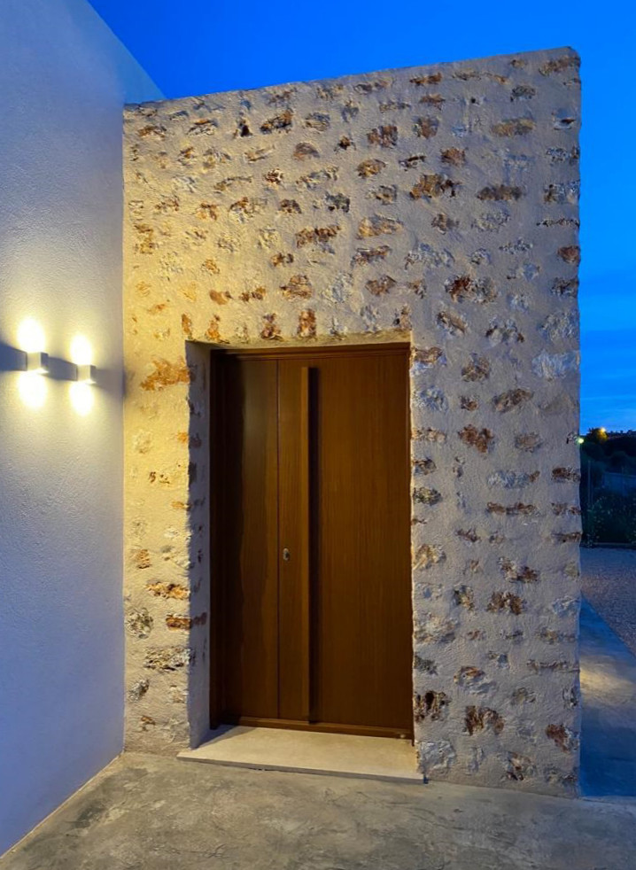 Imagen de fachada de casa blanca mediterránea grande de una planta con revestimiento de piedra y tejado plano