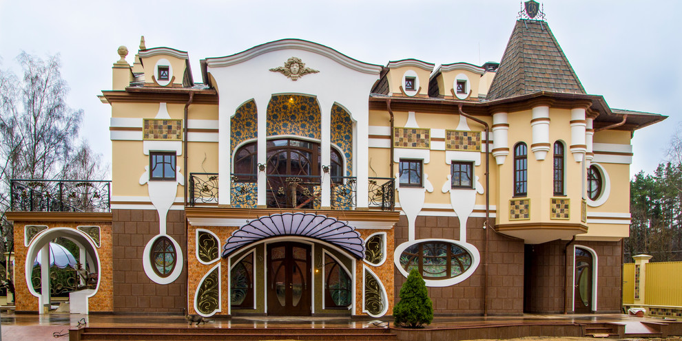 Immagine della facciata di una casa gialla classica a tre piani di medie dimensioni con rivestimenti misti e tetto a padiglione