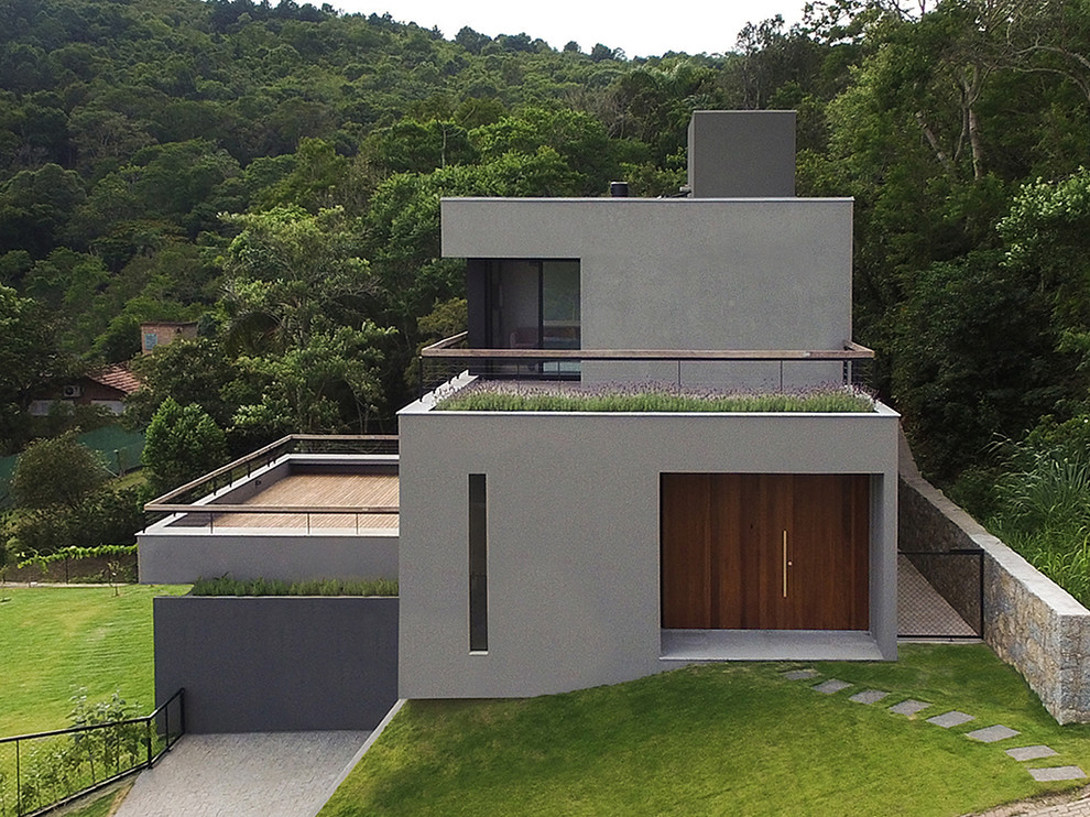 Example of a large minimalist gray three-story concrete fiberboard exterior home design in Other with a mixed material roof