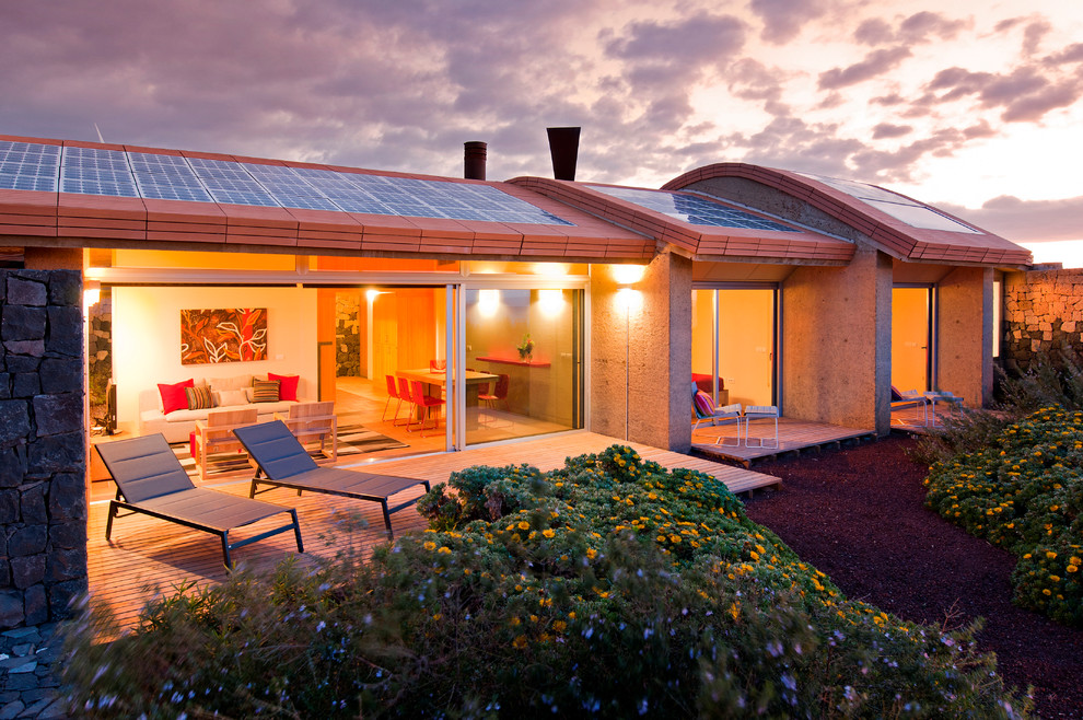 Cette image montre une petite façade de maison beige design de plain-pied avec un revêtement mixte.