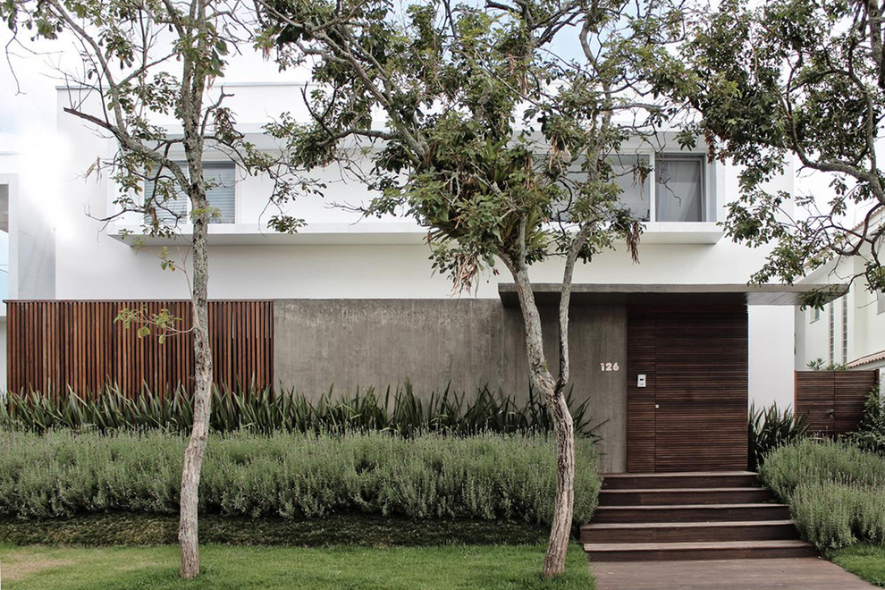Imagen de fachada de casa blanca minimalista grande de tres plantas con revestimiento de hormigón, tejado plano y techo verde