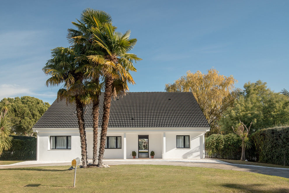 Imagen de fachada de casa blanca mediterránea grande de dos plantas con tejado a dos aguas