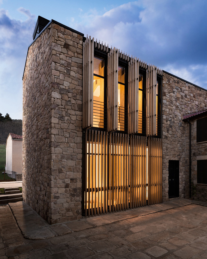 Идея дизайна: трехэтажный, коричневый частный загородный дом среднего размера в современном стиле с облицовкой из камня, двускатной крышей и черепичной крышей