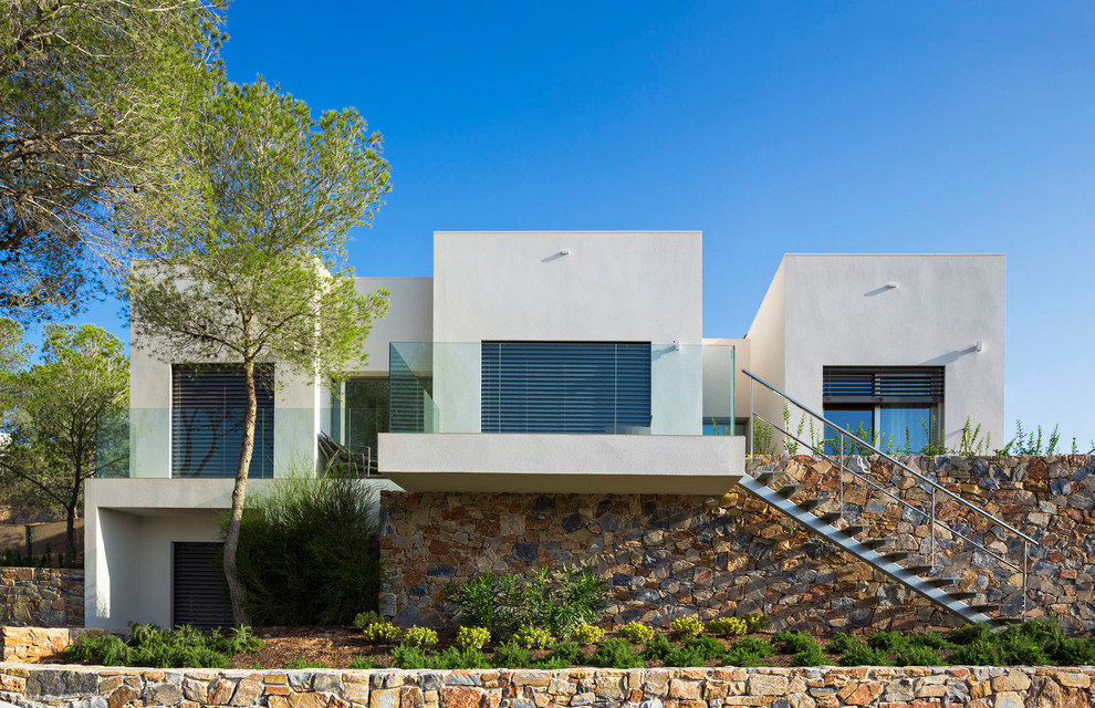 Imagen de fachada de casa blanca moderna grande de dos plantas con revestimientos combinados y tejado plano
