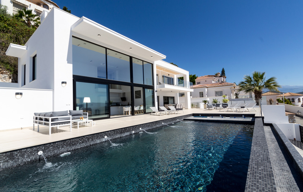 Großes, Zweistöckiges Modernes Einfamilienhaus mit Steinfassade, weißer Fassadenfarbe und Flachdach in Sonstige