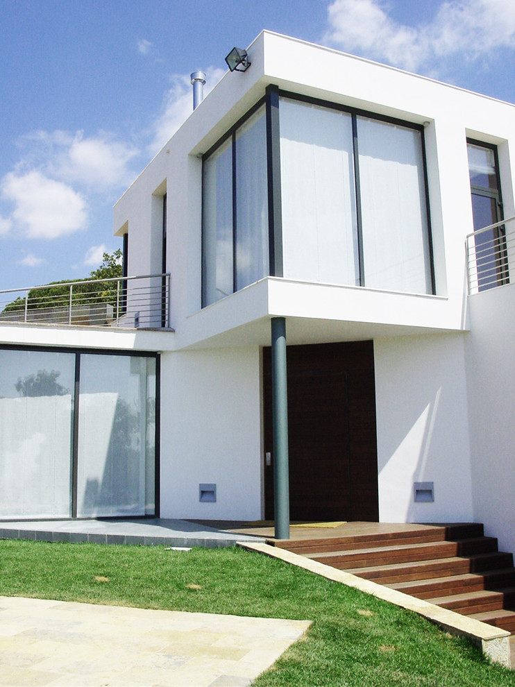 Exemple d'une grande façade de maison blanche tendance à un étage avec un toit plat.