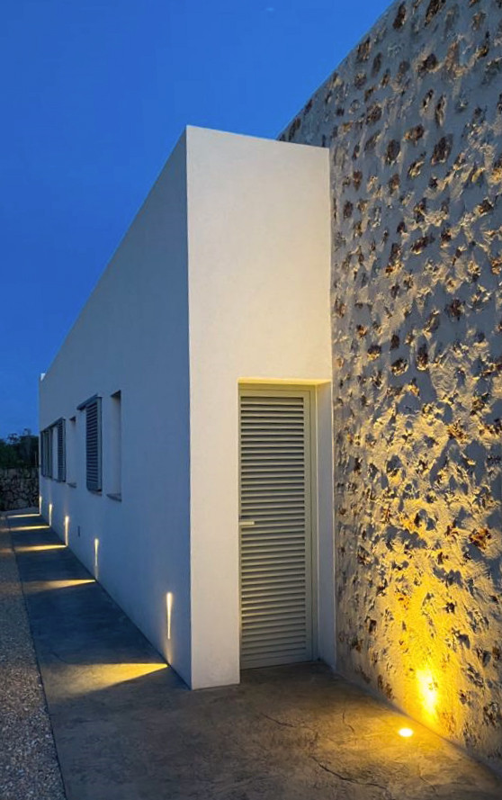 Imagen de fachada de casa blanca mediterránea grande de una planta con revestimiento de piedra y tejado plano