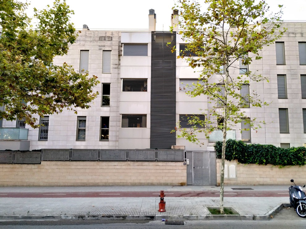 Foto della facciata di un appartamento ampio beige moderno a tre piani con rivestimento in pietra e tetto piano