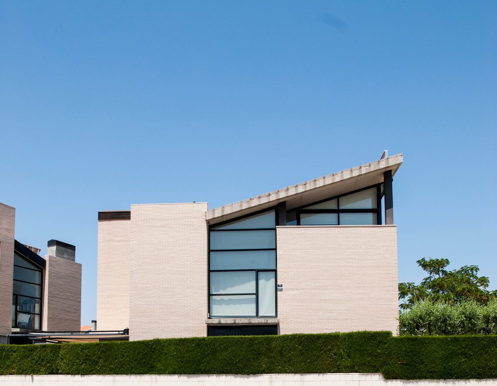 Mittelgroße, Dreistöckige Moderne Doppelhaushälfte mit Backsteinfassade, weißer Fassadenfarbe, Pultdach und Ziegeldach in Sonstige