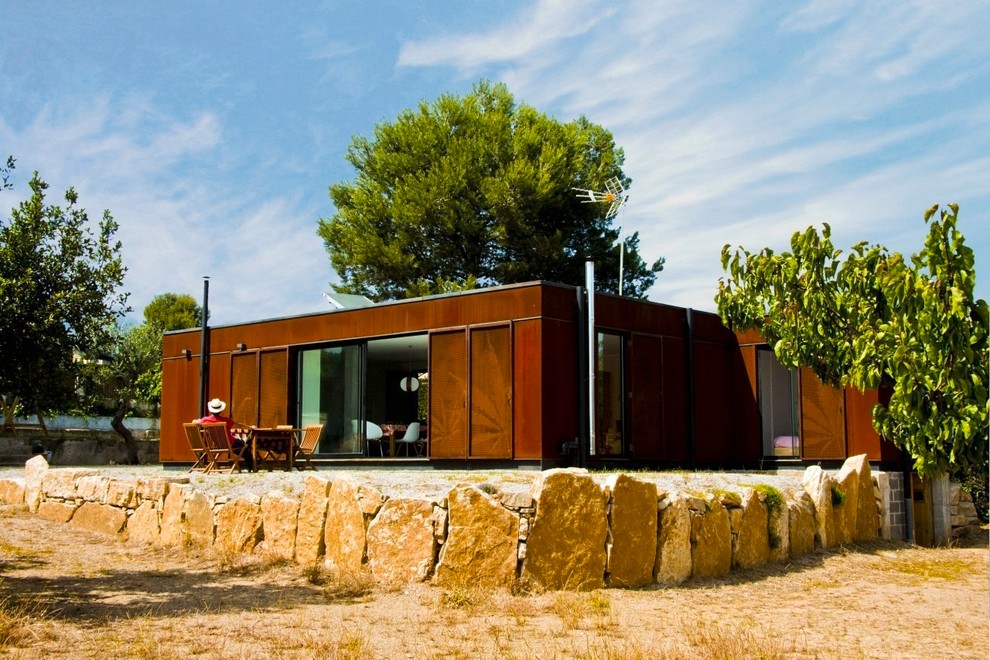 Пример оригинального дизайна: одноэтажный дом в современном стиле с облицовкой из металла и плоской крышей
