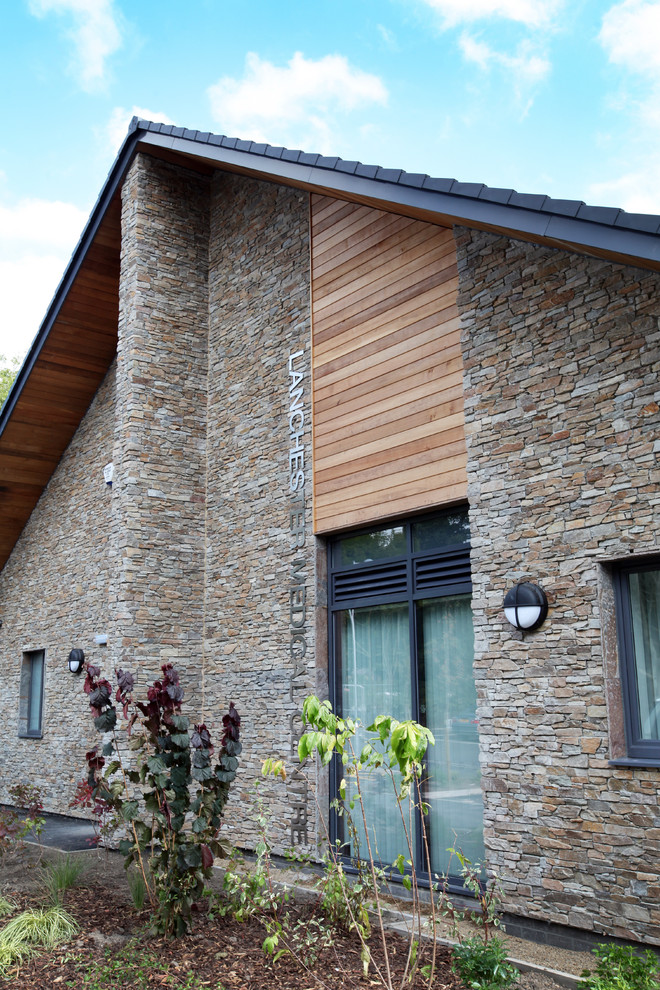 Foto de fachada de casa pareada marrón rural de tamaño medio de dos plantas con revestimiento de piedra y tejado a dos aguas