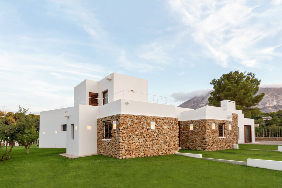 Foto de fachada de casa multicolor mediterránea de tamaño medio de dos plantas con revestimientos combinados y tejado plano