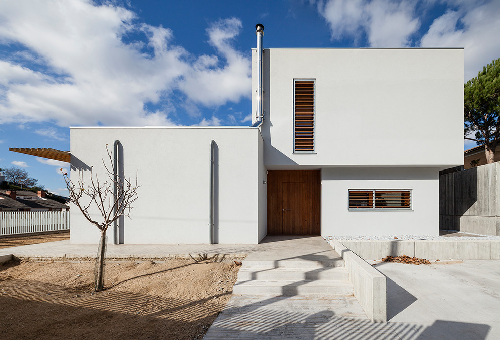 Mittelgroßes Modernes Haus mit weißer Fassadenfarbe, Flachdach und Putzfassade in Barcelona