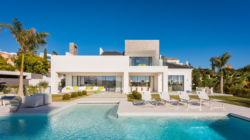 Diseño de fachada de casa blanca mediterránea grande de dos plantas con revestimientos combinados y tejado plano