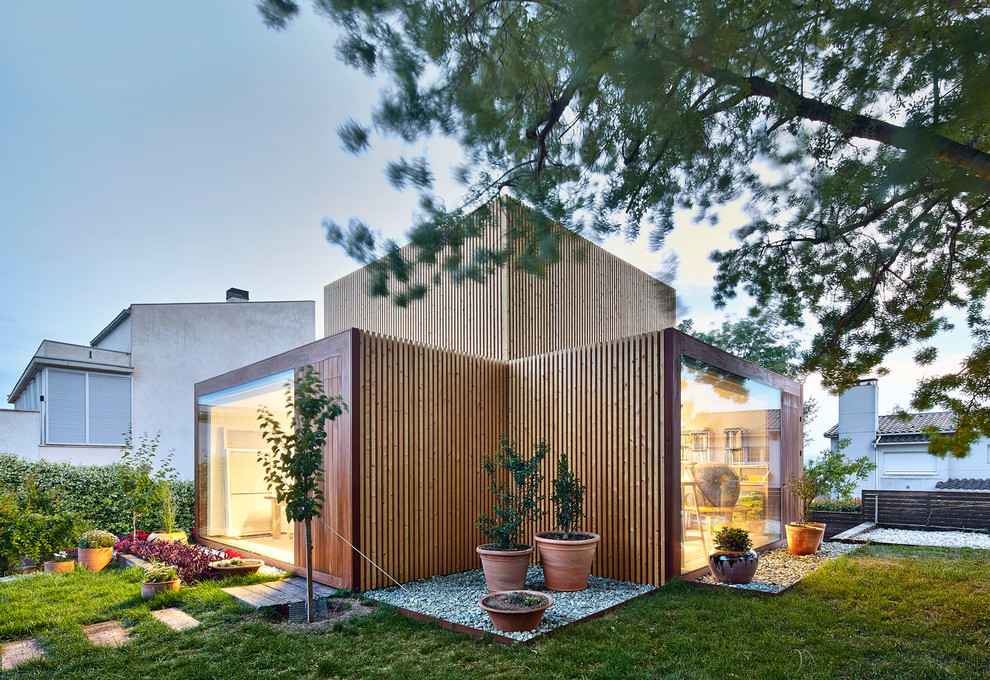 Стильный дизайн: двухэтажный, деревянный, коричневый частный загородный дом среднего размера в скандинавском стиле с плоской крышей - последний тренд