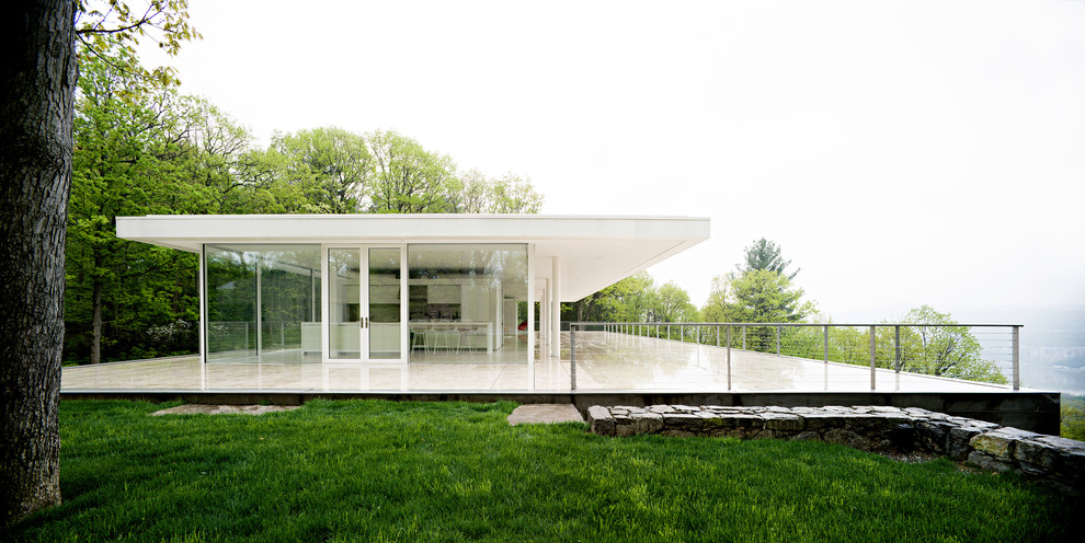 Inspiration pour une façade de maison blanche minimaliste en verre de taille moyenne et à un étage avec un toit plat.