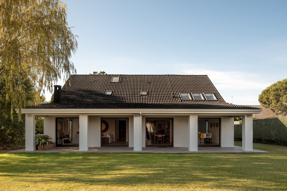 Ejemplo de fachada de casa blanca contemporánea grande de dos plantas con revestimiento de estuco, tejado a dos aguas y tejado de teja de barro