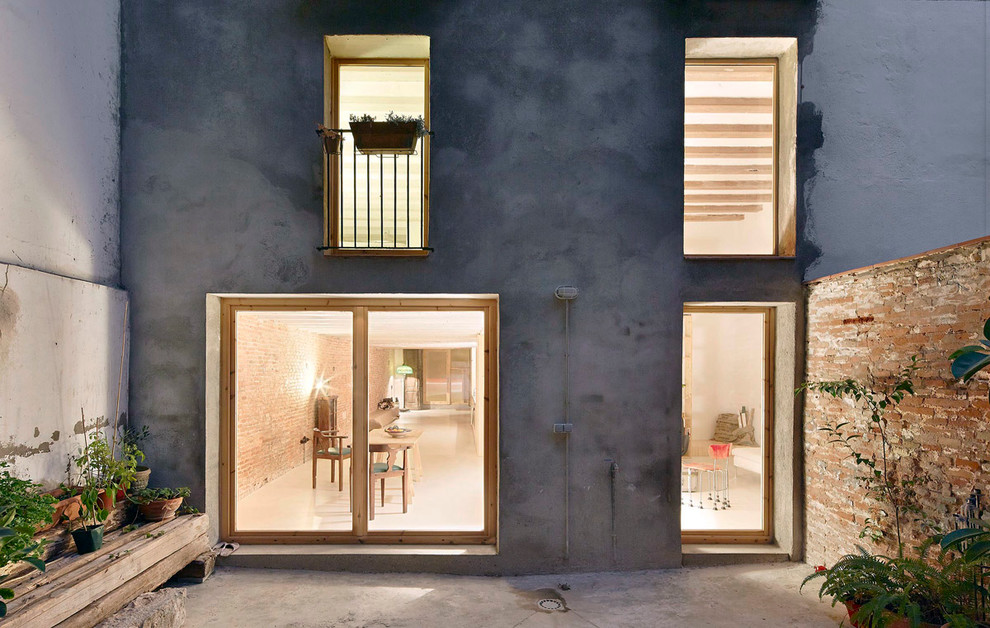 Mittelgroßes, Zweistöckiges Industrial Haus mit Betonfassade und grauer Fassadenfarbe in Barcelona