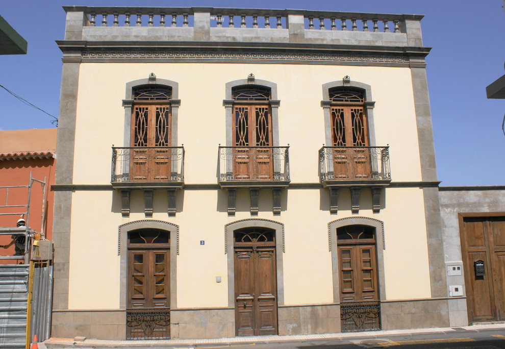 他の地域にあるお手頃価格の中くらいな地中海スタイルのおしゃれな家の外観 (混合材サイディング、黄色い外壁) の写真