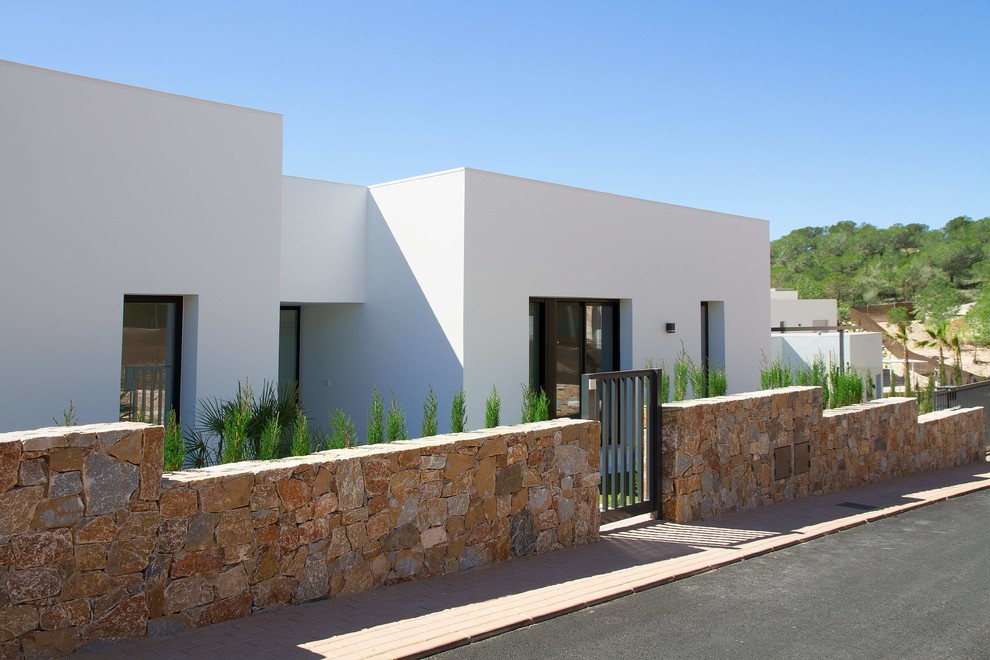 Imagen de fachada de casa blanca minimalista de una planta con tejado plano y tejado de varios materiales